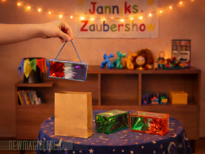 Dieser Zaubertrick ist die kleinere Version speziell für Kinder. Aus einer leeren Papiertüte produzieren Sie nach und nach drei hübsche mit Blumen gefüllte Boxen.